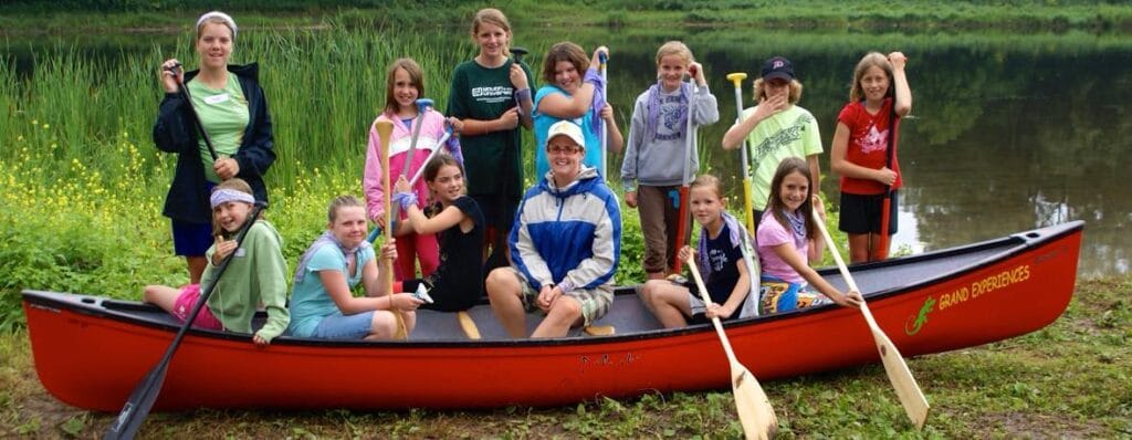 A group of youth learning to paddle kayaks and canoes on the grand river in Paris Ontario