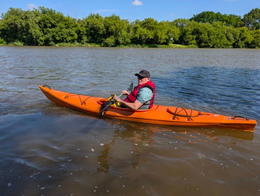 Man in an orange kayak paddling from Glen Morris to Paris