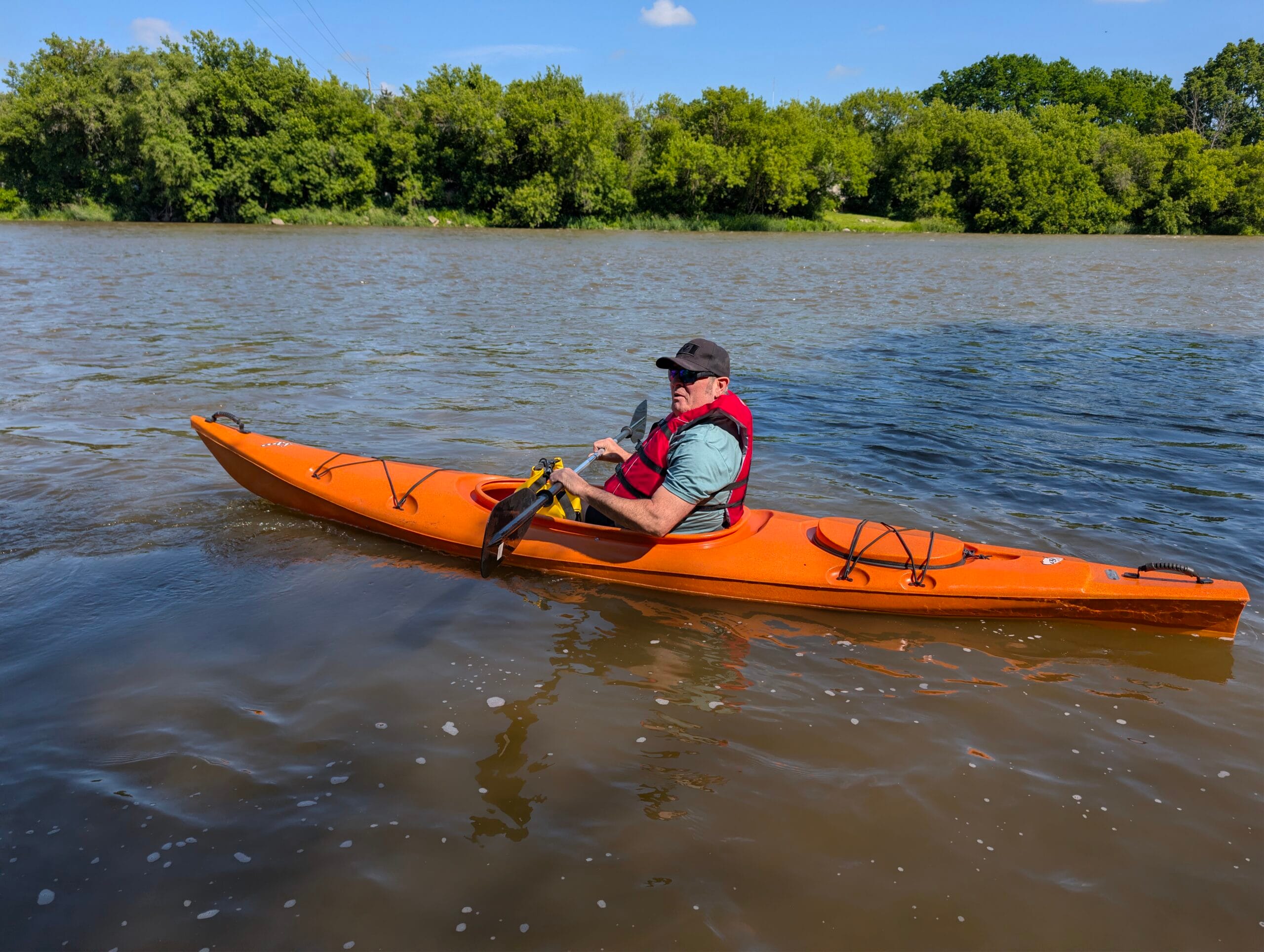 Man in an orange kayak paddling from Glen Morris to Paris