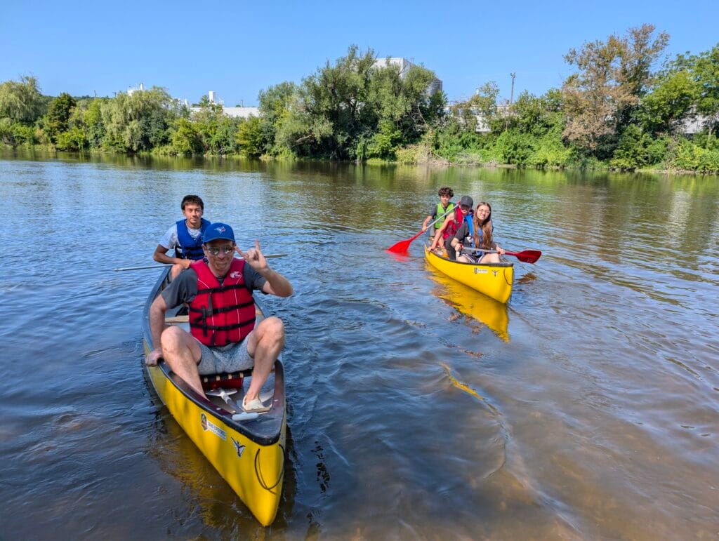 Family embarking on the cambridge to paris trip in canoes