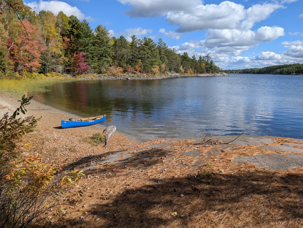 Blue canoe parked on a sandy beach on a provincial park site